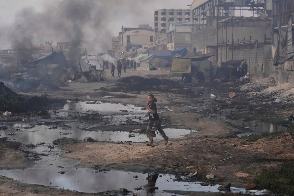 A Palestinian girl runs past the ruins of destroyed buildings along the Gaza City shoreline. Photo: AP