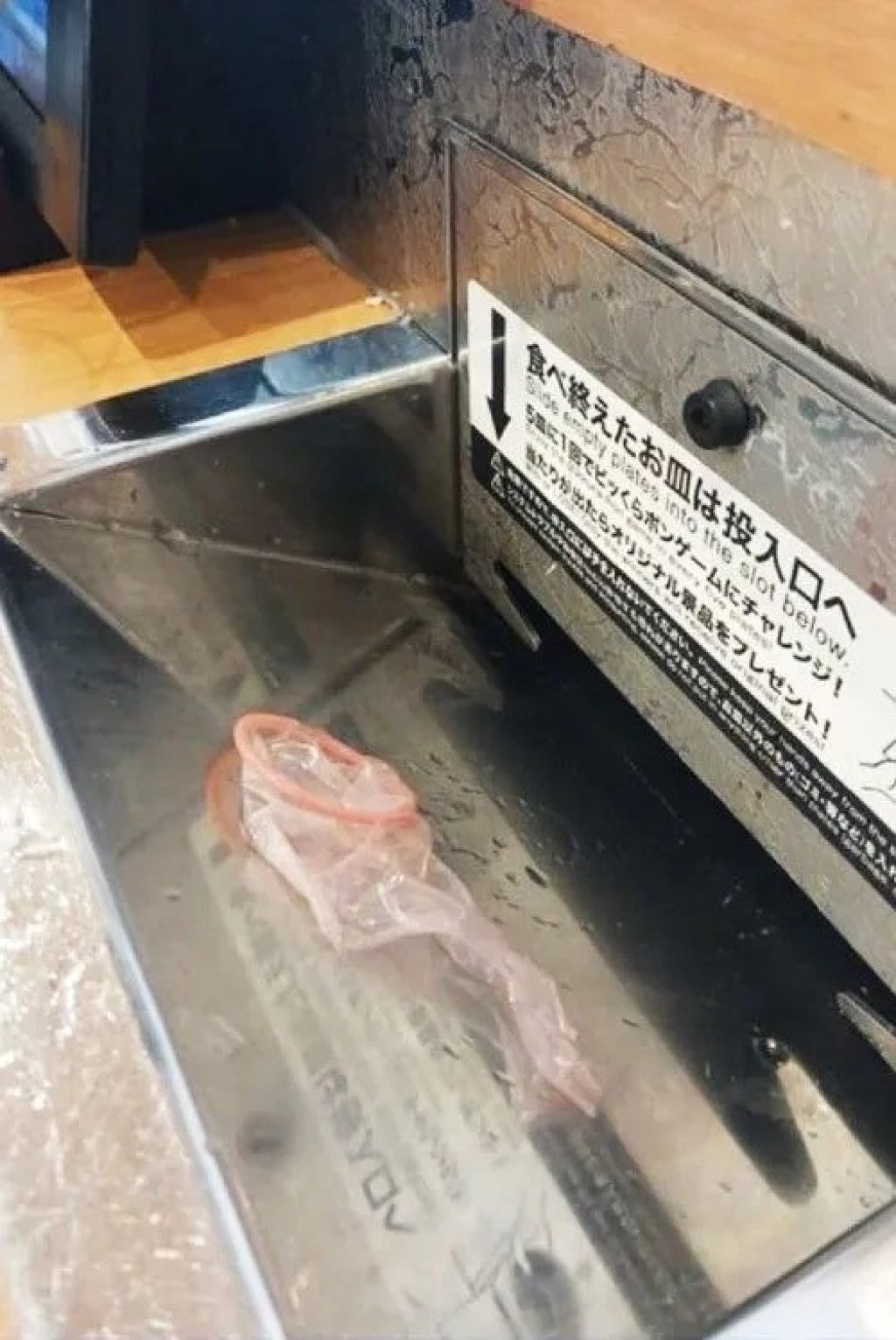 This image, showing the unwrapped condom in the slot used to collect empty plates at a sushi restaurant, went viral after being posted to social media on March 28. Photo: X This image, showing the unwrapped condom in the slot used to collect empty plates at a sushi restaurant, went viral after being posted to social media on March 28. Photo: X