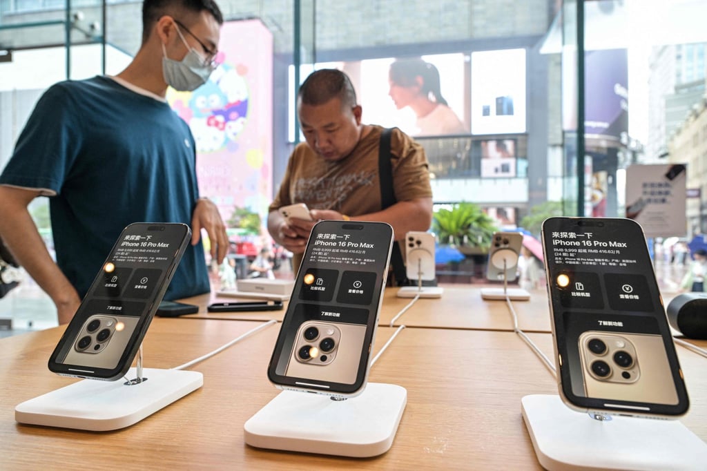 An Apple Store staff member (left) looks on as a shopper checks out an iPhone on display at the shop in Shanghai’s Huangpu district on Monday. Photo: AFP An Apple Store staff member (left) looks on as a shopper checks out an iPhone on display at the shop in Shanghai’s Huangpu district on Monday. Photo: AFP