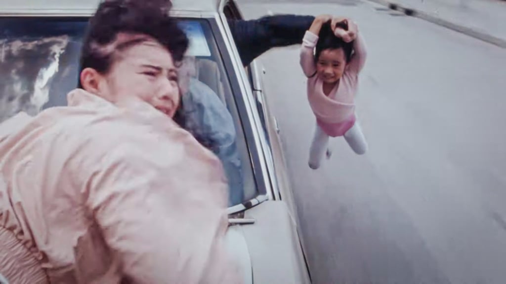 A child is dangled from a moving car while Moon Lee Choi-fung clings to the bonnet in 1990’s Fatal Termination. Photo: Golden Sun Films A child is dangled from a moving car while Moon Lee Choi-fung clings to the bonnet in 1990’s Fatal Termination. Photo: Golden Sun Films