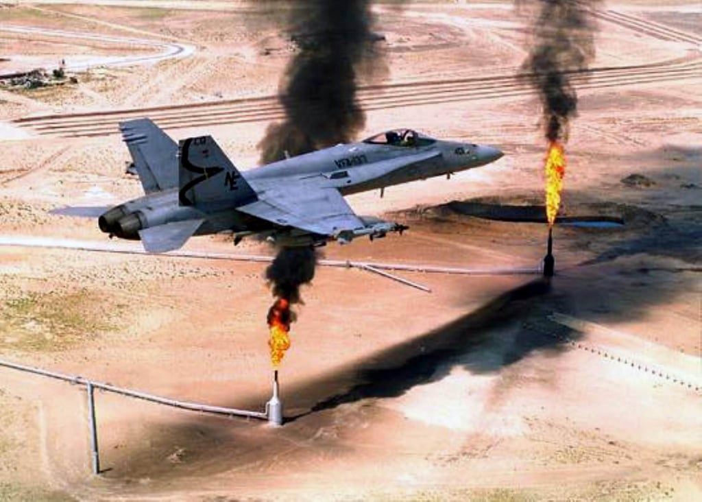 A US F-18 fighter jet flies over gas flares at an oil well in northern Kuwait in 1995. Photo: AFP A US F-18 fighter jet flies over gas flares at an oil well in northern Kuwait in 1995. Photo: AFP
