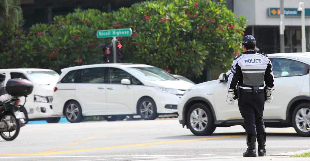 A police officer keeps an eye on downtown traffic in Singapore. Photo: Shutterstock A police officer keeps an eye on downtown traffic in Singapore. Photo: Shutterstock