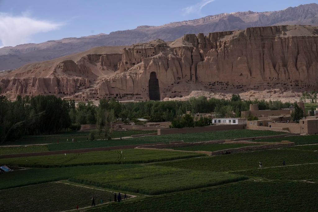 Villagers walk in the fields near the niche of the giant Buddha statue destroyed by the Taliban in 2001, in Bamiyan, Afghanistan, on June 17, 2023. Photo: AP