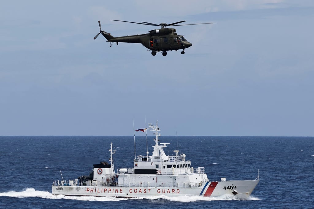 A Philippine Air Force helicopter passes above Philippine Coast Guard vessel BRP Cabra during a joint maritime activity with the US in disputed waters of the South China Sea in June. Photo: EPA-EFE