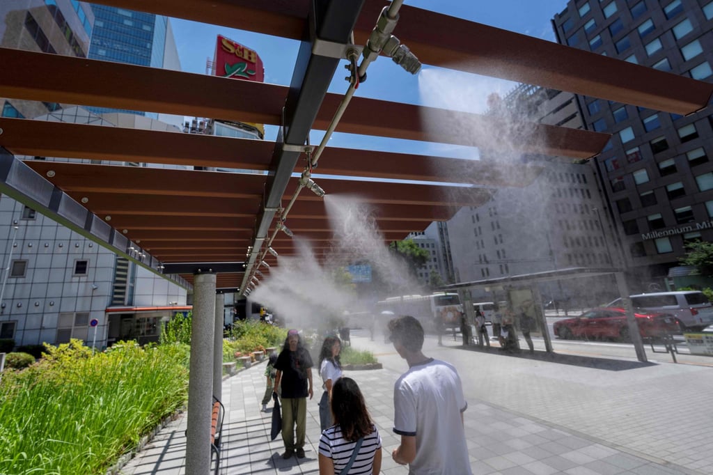 People rest under artificial mist to cool down on a hot day in Tokyo on June 28. Photo: AFP People rest under artificial mist to cool down on a hot day in Tokyo on June 28. Photo: AFP
