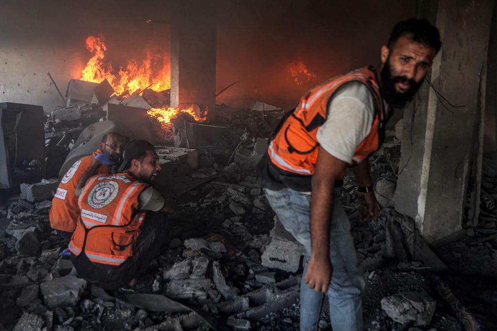 Palestinians try to extinguish a fire at a building hit by an Israeli strike in Gaza City on Wednesday. Photo: AFP Palestinians try to extinguish a fire at a building hit by an Israeli strike in Gaza City on Wednesday. Photo: AFP