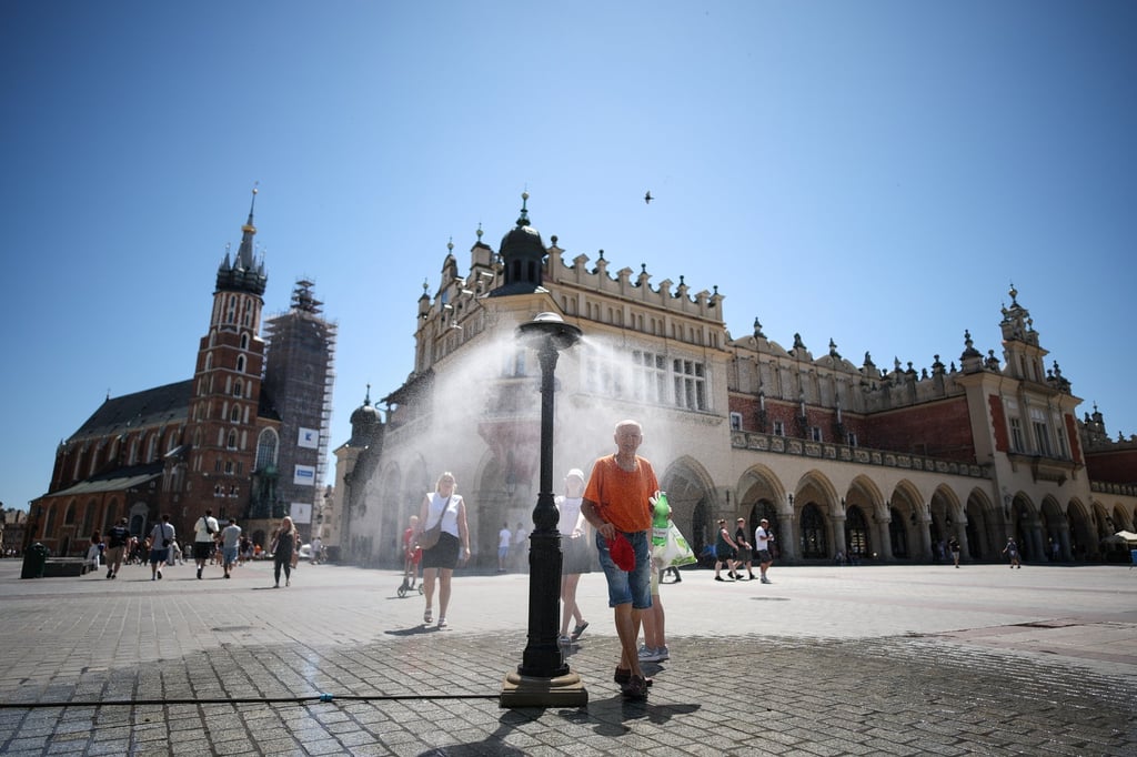 People cool down at a public water sprinkler during a heatwave in Krakow, Poland, on Wednesday. Photo: EPA