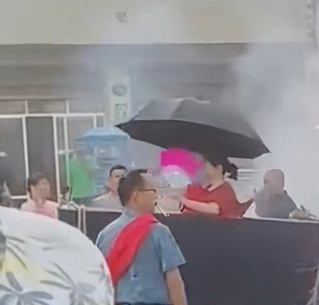 The woman, equipped with an umbrella and a fan, sits inside the coffin as the procession gets underway. Photo: Douyin The woman, equipped with an umbrella and a fan, sits inside the coffin as the procession gets underway. Photo: Douyin