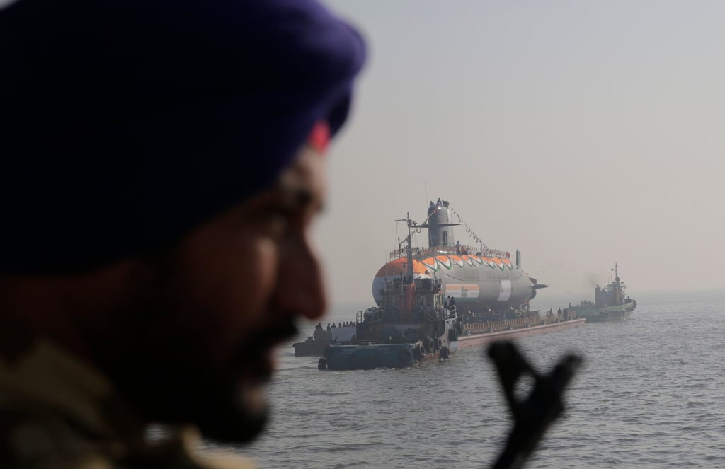 A security man stands guard as an Indian navy submarine is set afloat during its launch at the Mazagon Dock Shipbuilders in Mumbai. Photo: AP