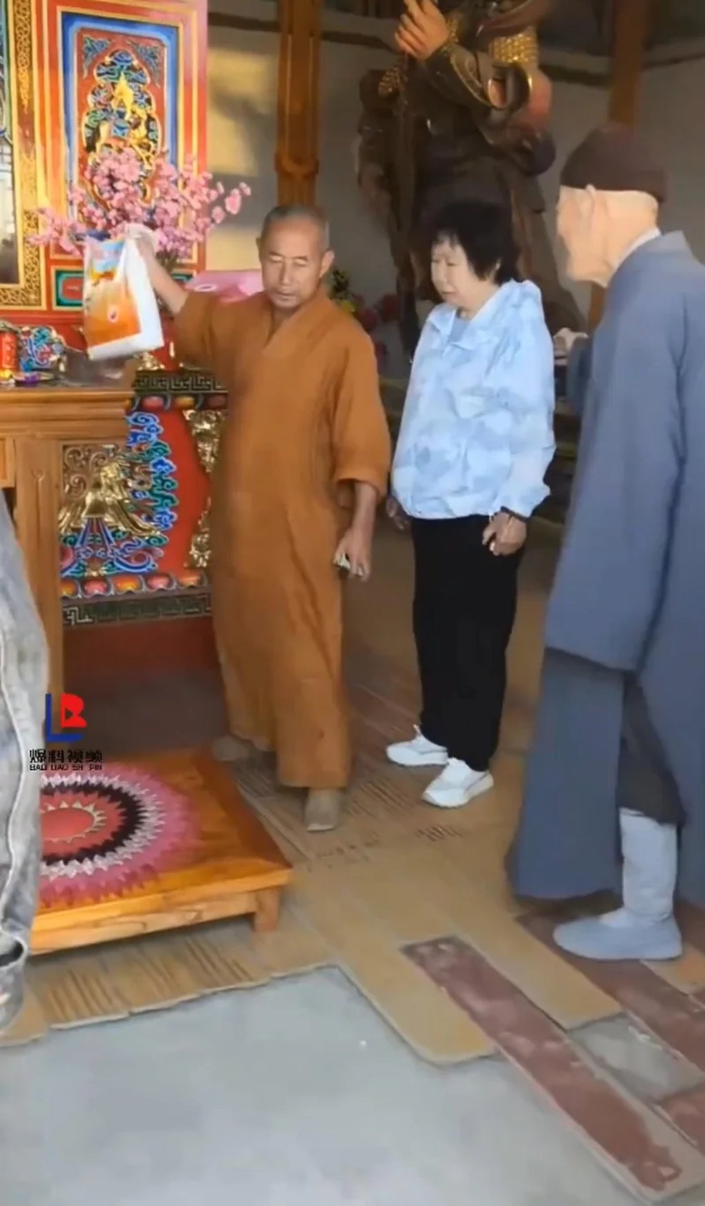 The monk holds up the couple’s bag of rice as he accuses them of not being “sincere”. Photo: Douyin The monk holds up the couple’s bag of rice as he accuses them of not being “sincere”. Photo: Douyin