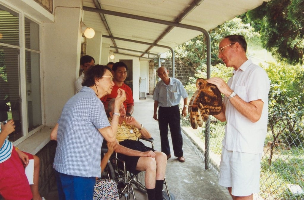 Gary Ades’ father, Jim Ades (right), holding a grass owl, while talking to orchid expert Gloria Barretto (left) and Sir Horace Kadoorie (In wheelchair), outside his office in Shek Kong, Hong Kong, in 1993. Photo: courtesy Gary Ades Gary Ades’ father, Jim Ades (right), holding a grass owl, while talking to orchid expert Gloria Barretto (left) and Sir Horace Kadoorie (In wheelchair), outside his office in Shek Kong, Hong Kong, in 1993. Photo: courtesy Gary Ades