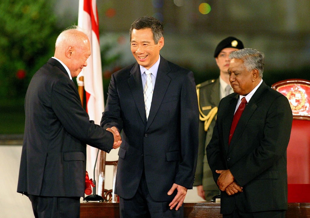 Singaporean Prime Minister Lee Hsien Loong, centre, shakes hands with his father, Minister Mentor Lee Kuan Yew, while standing next to President S.R. Nathan, right, on August. 12, 2004. Photo: AP Singaporean Prime Minister Lee Hsien Loong, centre, shakes hands with his father, Minister Mentor Lee Kuan Yew, while standing next to President S.R. Nathan, right, on August. 12, 2004. Photo: AP