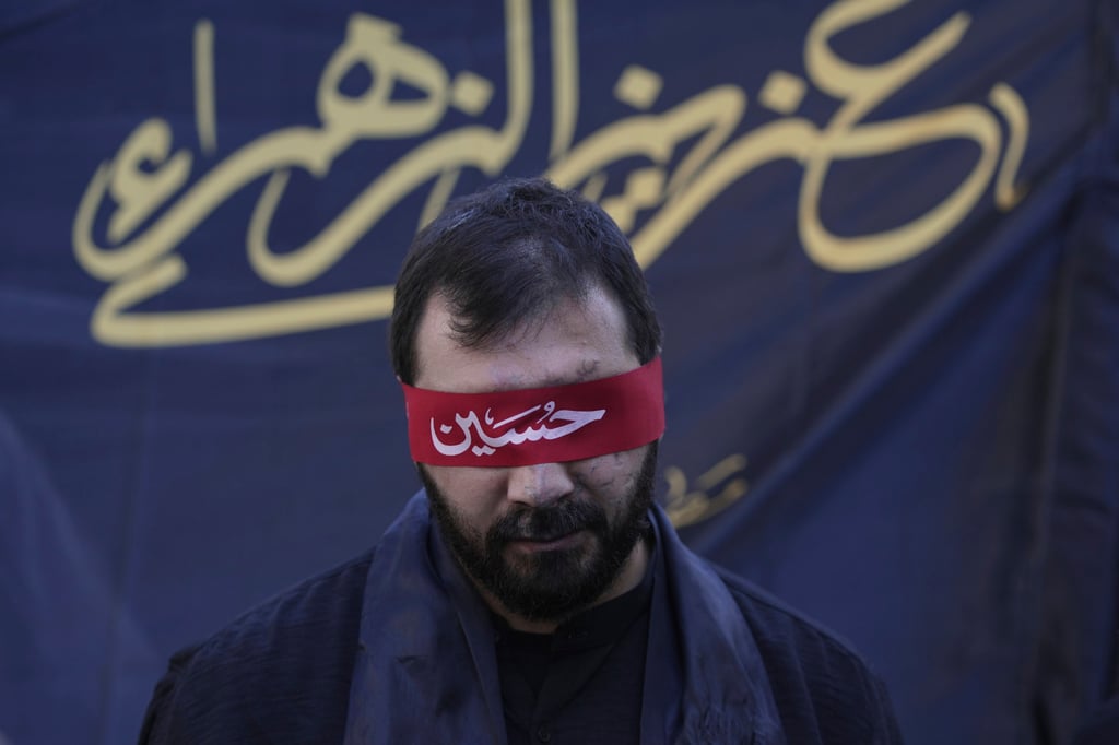 A Hezbollah supporter who lost his sight in a pager attack carried out by Israel on September 17 last year, covers his eyes with a red headband inscribed with the name ‘Hussein’ during Ashoura, the Shiite Muslim commemoration marking the 7th-century death of Imam Hussein, in Beirut, Lebanon, on Sunday. Photo: AP A Hezbollah supporter who lost his sight in a pager attack carried out by Israel on September 17 last year, covers his eyes with a red headband inscribed with the name ‘Hussein’ during Ashoura, the Shiite Muslim commemoration marking the 7th-century death of Imam Hussein, in Beirut, Lebanon, on Sunday. Photo: AP