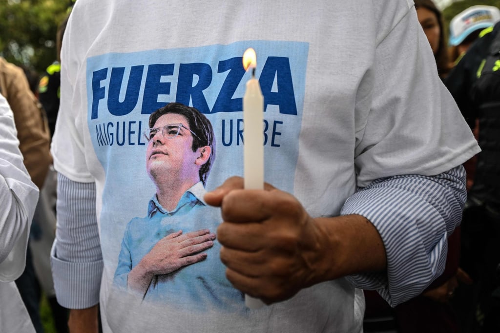 A man wearing a T-shirt with the image of Colombian politician Miguel Uribe holds a candle during a mass for Uribe’s health in Bogota in June. Photo: AFP A man wearing a T-shirt with the image of Colombian politician Miguel Uribe holds a candle during a mass for Uribe’s health in Bogota in June. Photo: AFP