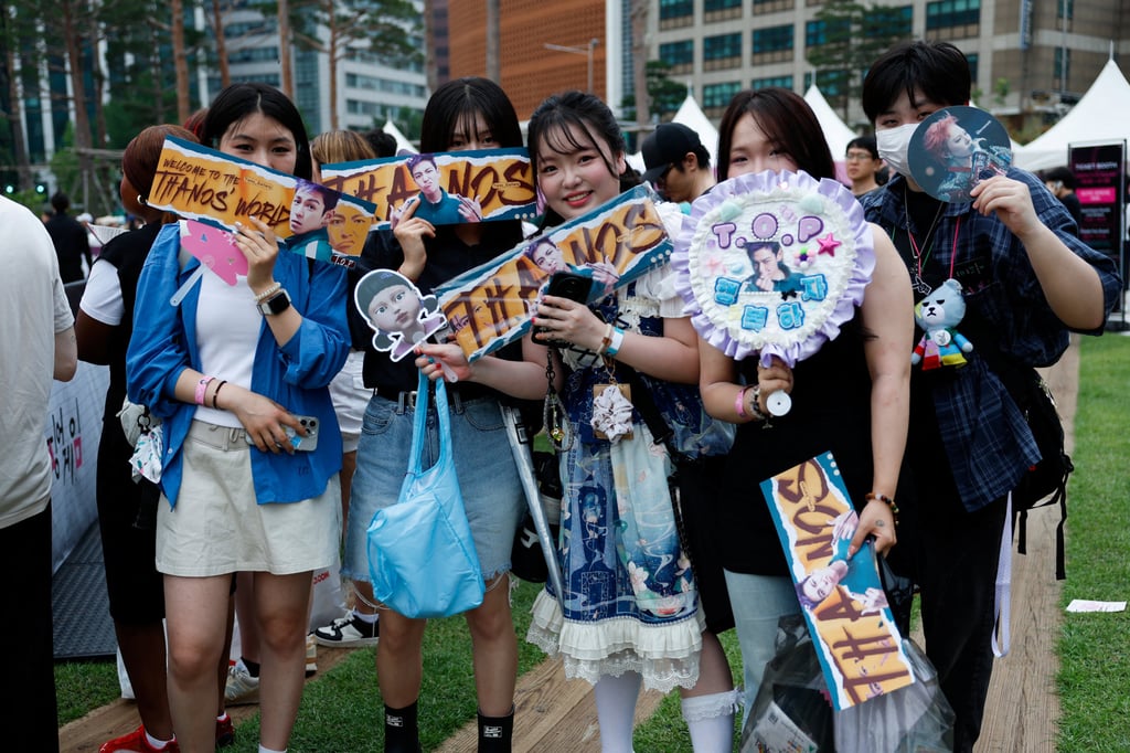 Fans of Squid Game hold signs before a parade through central Seoul, which was followed by a fan event with the cast to celebrate the third season of Netflix’s hit series, on June 28, 2025. Photo: Reuters