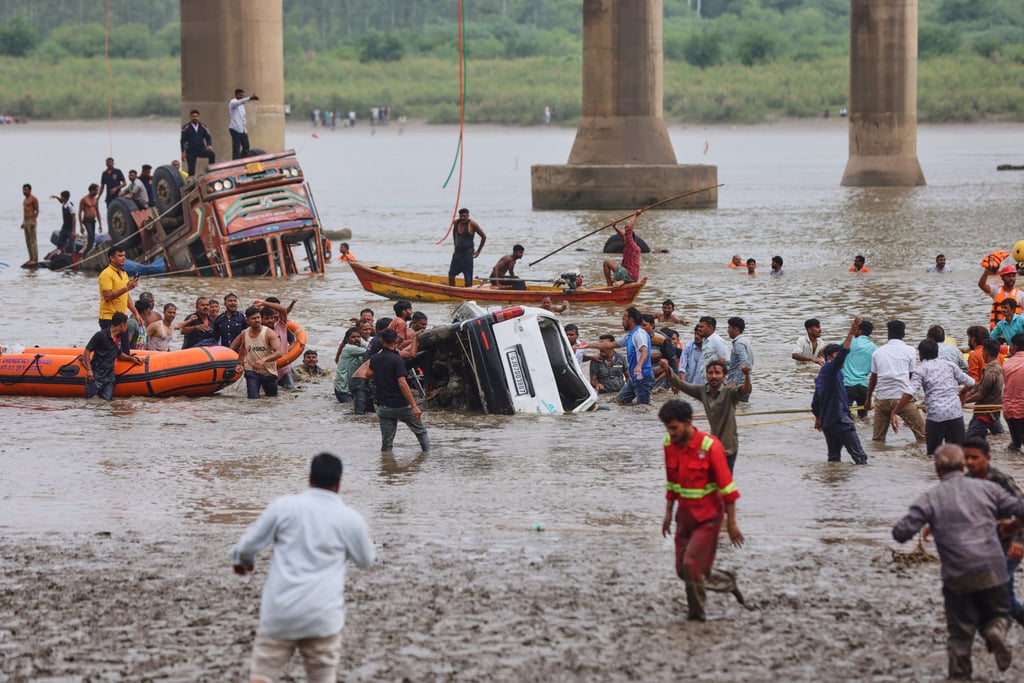 Rescuers and locals look for survivors after several vehicles fell into a river following the collapse of a portion of a bridge in the Indian state of Gujarat on Wednesday. Photo: AP Rescuers and locals look for survivors after several vehicles fell into a river following the collapse of a portion of a bridge in the Indian state of Gujarat on Wednesday. Photo: AP