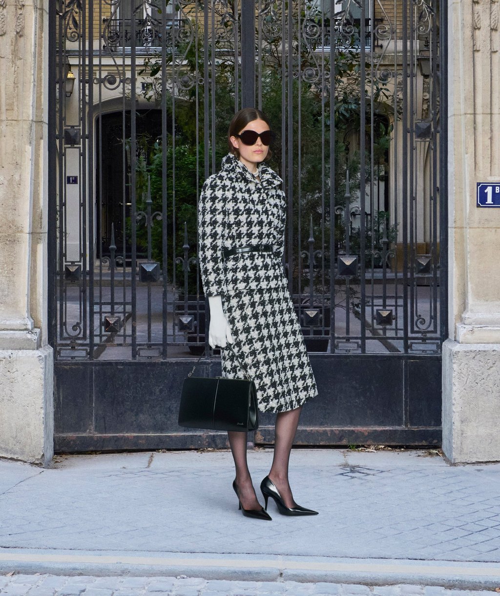 A houndstooth skirt suit paired with a ladylike handbag and jewellery by Lorraine Schwartz. Photo: Handout