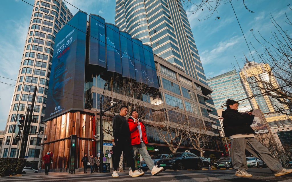 People cross a street near a screen showing stock exchange and economic data in Shanghai. Photo: EPA-EFE People cross a street near a screen showing stock exchange and economic data in Shanghai. Photo: EPA-EFE