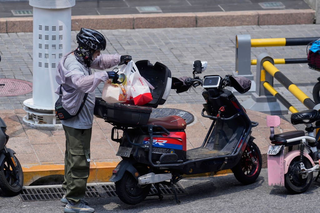 An online food delivery rider sorts out orders in Beijing on July 11, 2025. Photo: AP An online food delivery rider sorts out orders in Beijing on July 11, 2025. Photo: AP