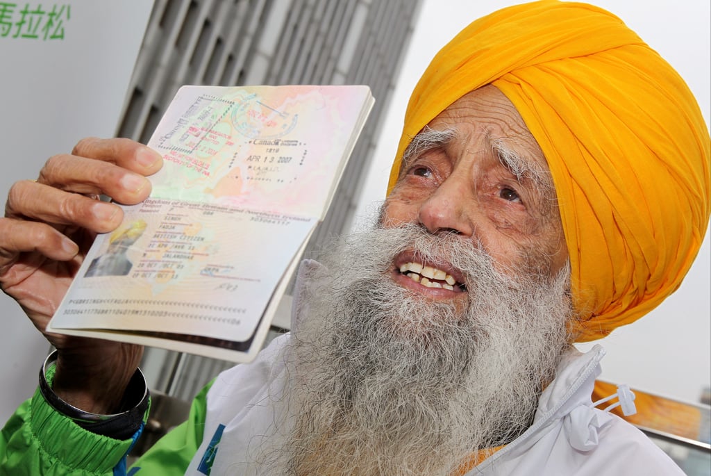 Fauja Singh, then 101, shows his passport in Causeway Bay ahead of a 10km race at the Hong Kong Marathon event. Photo: K. Y. Cheng Fauja Singh, then 101, shows his passport in Causeway Bay ahead of a 10km race at the Hong Kong Marathon event. Photo: K. Y. Cheng