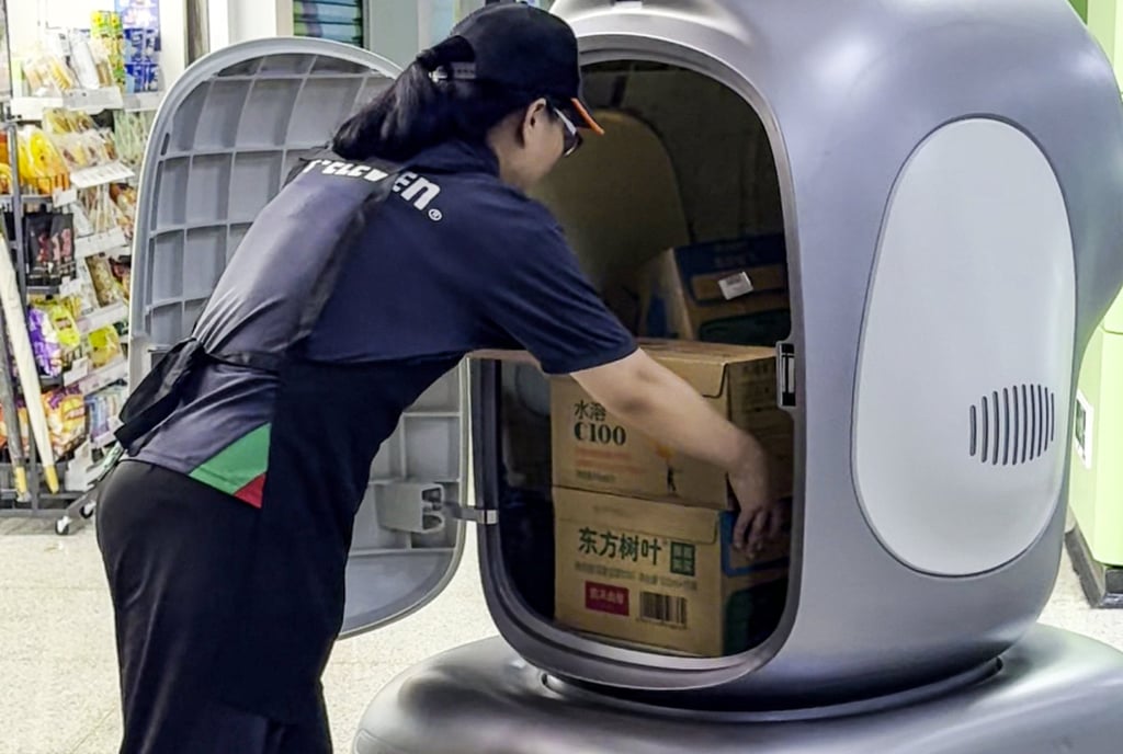 A 7-Eleven staff member unloads goods delivered by one of the robots at a store inside a subway station in Shenzhen, Guangdong province. Photo: Handout A 7-Eleven staff member unloads goods delivered by one of the robots at a store inside a subway station in Shenzhen, Guangdong province. Photo: Handout