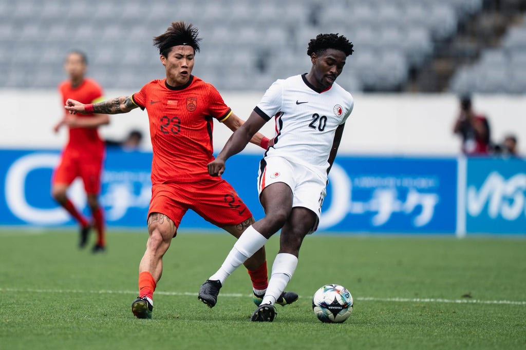 Hong Kong’s Michael Udebuluzor (right) is tackled by China’s Xie Wenneng. Photo: HKFA