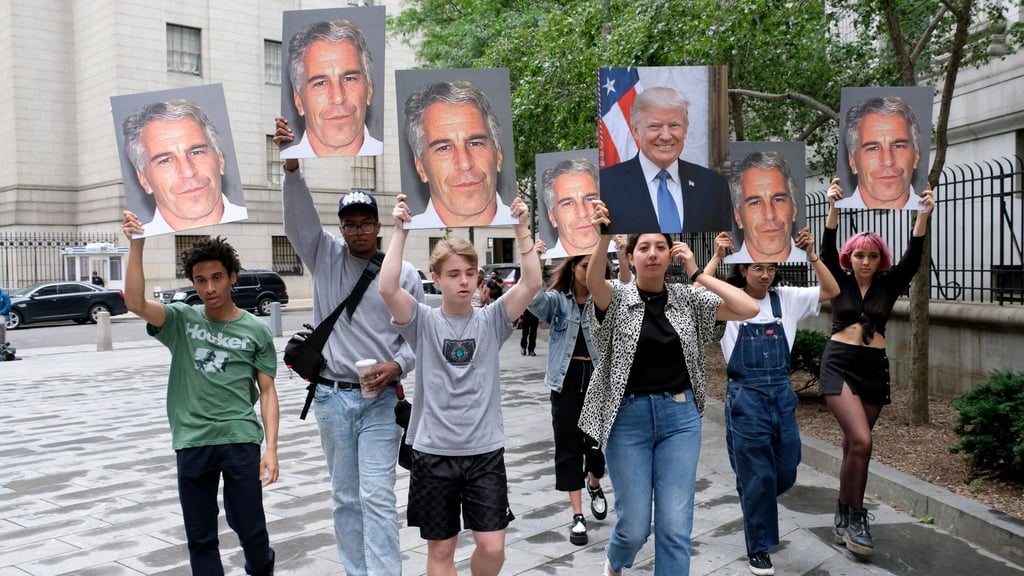 Protesters hold pictures of Jeffrey Epstein and Donald Trump outside federal court in downtown Manhattan in 2019. File photo: TNS