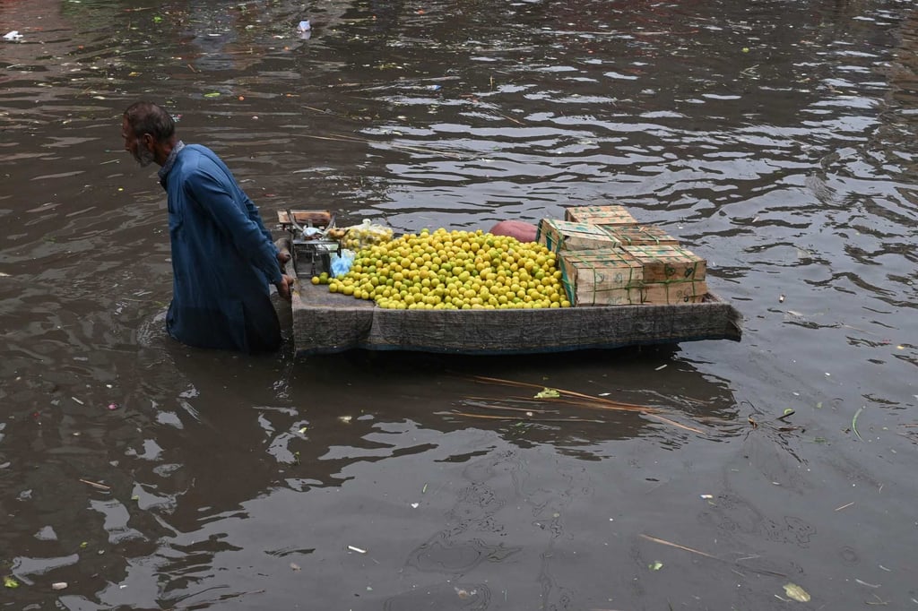 A vendor pulls his cart through flooded streets in Lahore on July 16. Photo: AFP