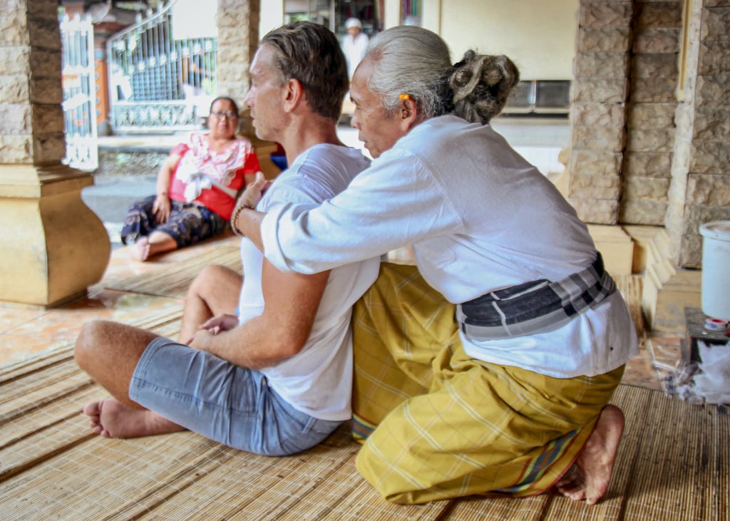 Mangku Sudarsana, aka the Bone Healer, giving writer Ian Lloyd Neubauer “a whopping back crack”. Photo: Ian Neubauer Mangku Sudarsana, aka the Bone Healer, giving writer Ian Lloyd Neubauer “a whopping back crack”. Photo: Ian Neubauer