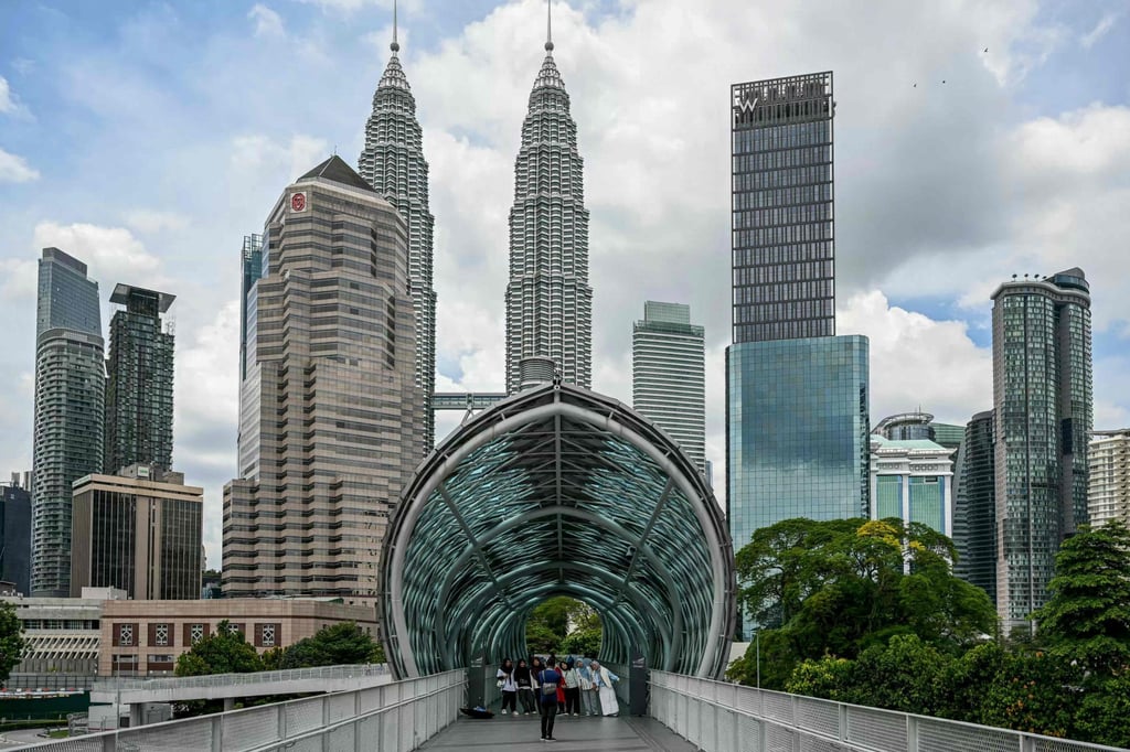 Tourists take pictures in Kuala Lumpur on Tuesday with the Petronas Twin Towers in the background. Photo: AFP