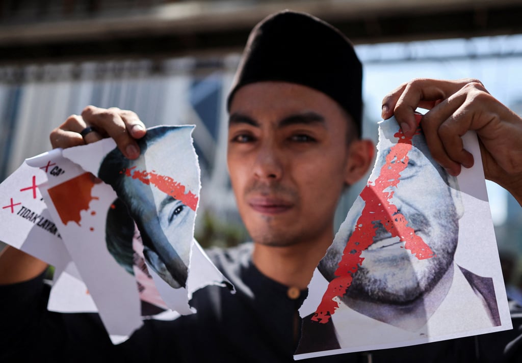 A protester holds a torn picture of Nick Adams, US President Donald Trump’s nomination as the country’s ambassador to Malaysia, outside the US embassy in Kuala Lumpur on Friday. Photo: Reuters