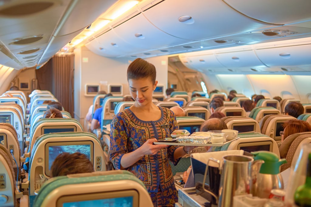 A Singapore Airlines flight attendant wearing a kebaya serves food and drinks. Photo: Shutterstock
