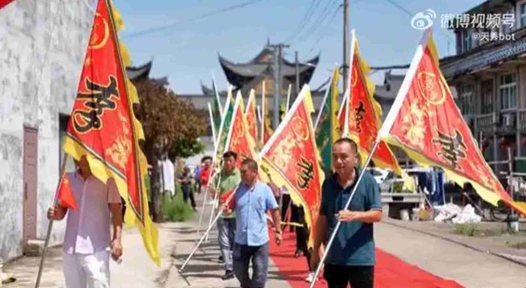 Warga desa merayakan hari istimewa ini dengan prosesi pengibaran bendera di jalanan. Foto: Weibo