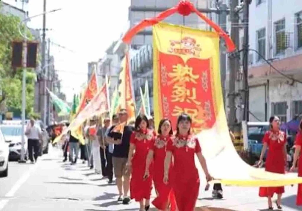Para perempuan juga turut serta dalam parade, mengenakan pakaian merah keberuntungan sambil membawa spanduk. Foto: Weibo