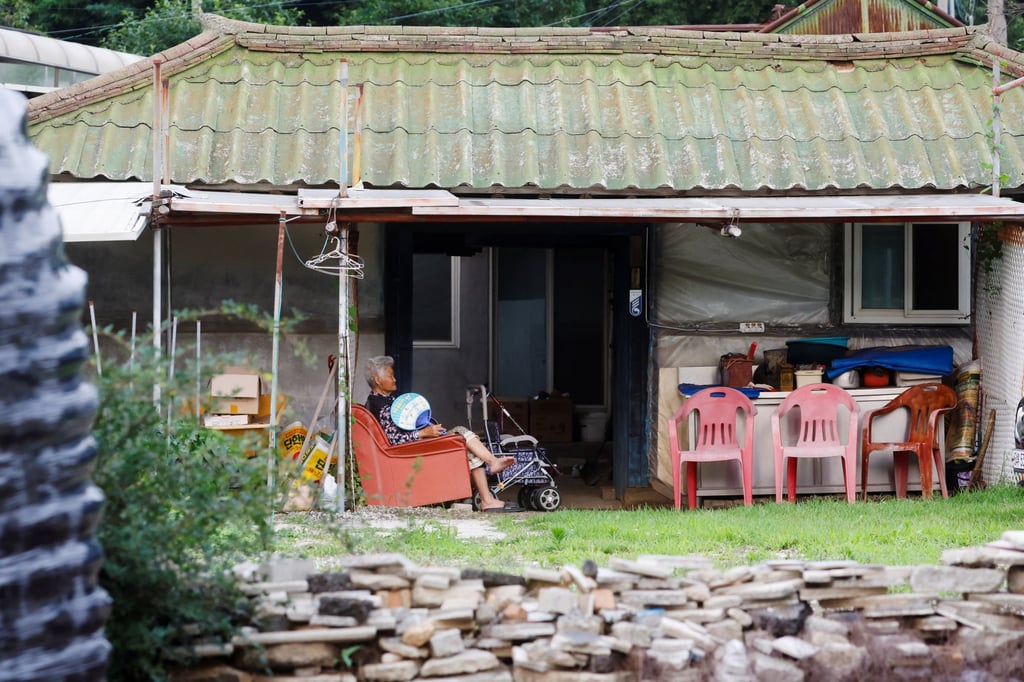 An elderly woman sits and rests in front of her house in a village in Dangsan-ri, near the North Korean border, on July 6 after the loudspeaker broadcasts had ceased. Photo: Reuters