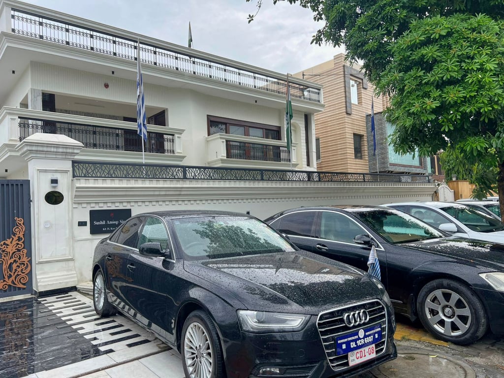 Luxury cars bearing fake diplomatic number plates parked outside a rented residential building in which a bogus embassy was operating in Ghaziabad, India. Photo: AP Luxury cars bearing fake diplomatic number plates parked outside a rented residential building in which a bogus embassy was operating in Ghaziabad, India. Photo: AP