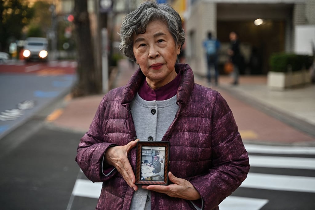 Shizue Takahashi, whose husband Kazumasa Takahashi was killed in the sarin gas attack in 1995, holds his photo outside a subway station in Tokyo in February. Photo: AFP Shizue Takahashi, whose husband Kazumasa Takahashi was killed in the sarin gas attack in 1995, holds his photo outside a subway station in Tokyo in February. Photo: AFP