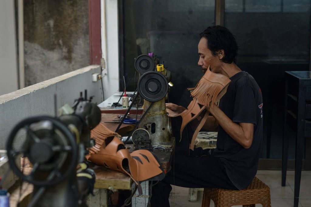 An artisan works on a pair of leather boots in Indonesia. Indonesian goods entering the US will face a 19 per cent tariff. Photo: AFP