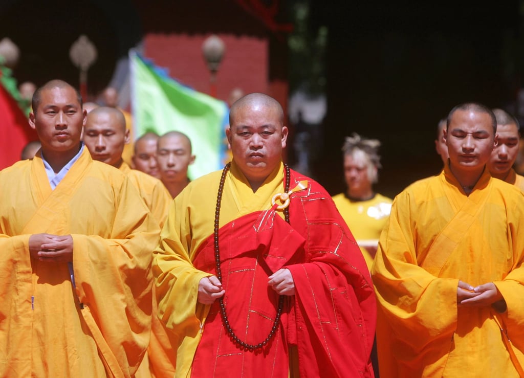 Shi Yongxin (centre), abbot of the Shaolin Temple in central China, is under joint investigation by multiple departments. Photo: Getty Images Shi Yongxin (centre), abbot of the Shaolin Temple in central China, is under joint investigation by multiple departments. Photo: Getty Images