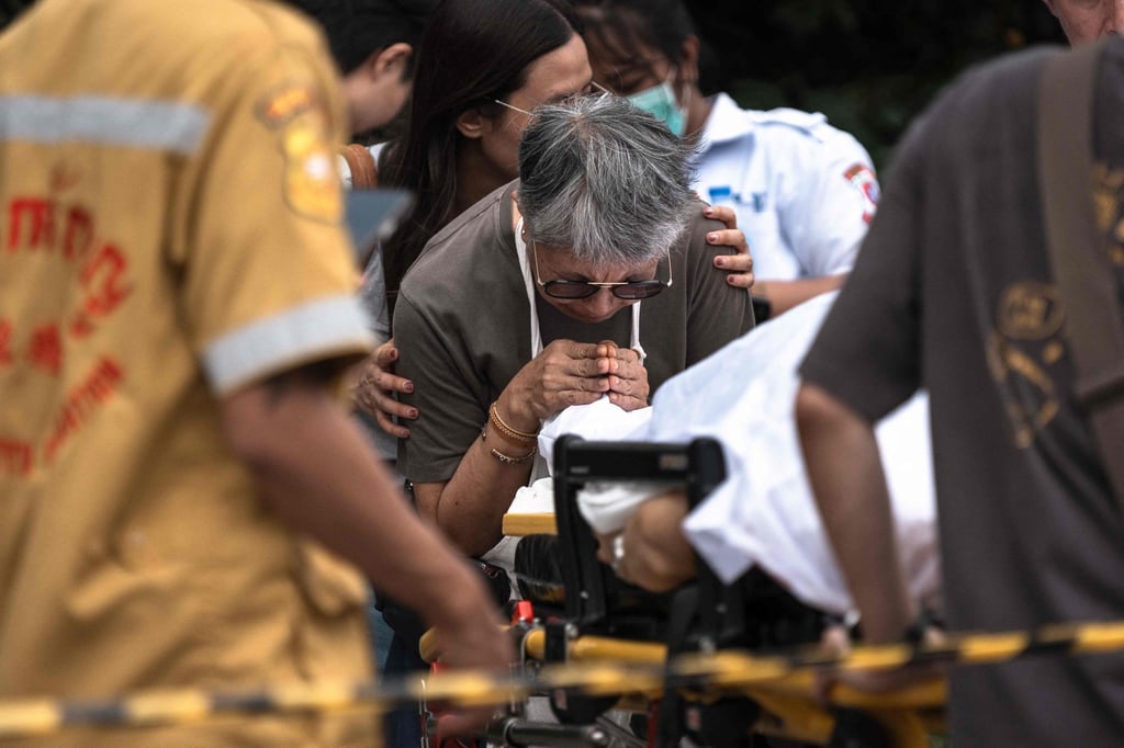 A woman reacts over the body of a shooting victim on a stretcher at Or Tor Kor market in Bangkok on Monday. Photo: AFP A woman reacts over the body of a shooting victim on a stretcher at Or Tor Kor market in Bangkok on Monday. Photo: AFP