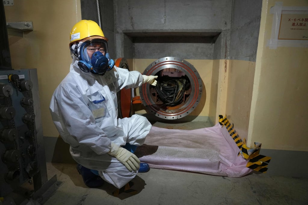 Nobuhide Sato, a risk communicator at Tepco shows the X-6 penetration, a hole a device must pass for fuel debris retrieval during a visit to Unit 5 of the Fukushima Daiichi Nuclear Power Plant in February. Photo: AFP Nobuhide Sato, a risk communicator at Tepco shows the X-6 penetration, a hole a device must pass for fuel debris retrieval during a visit to Unit 5 of the Fukushima Daiichi Nuclear Power Plant in February. Photo: AFP