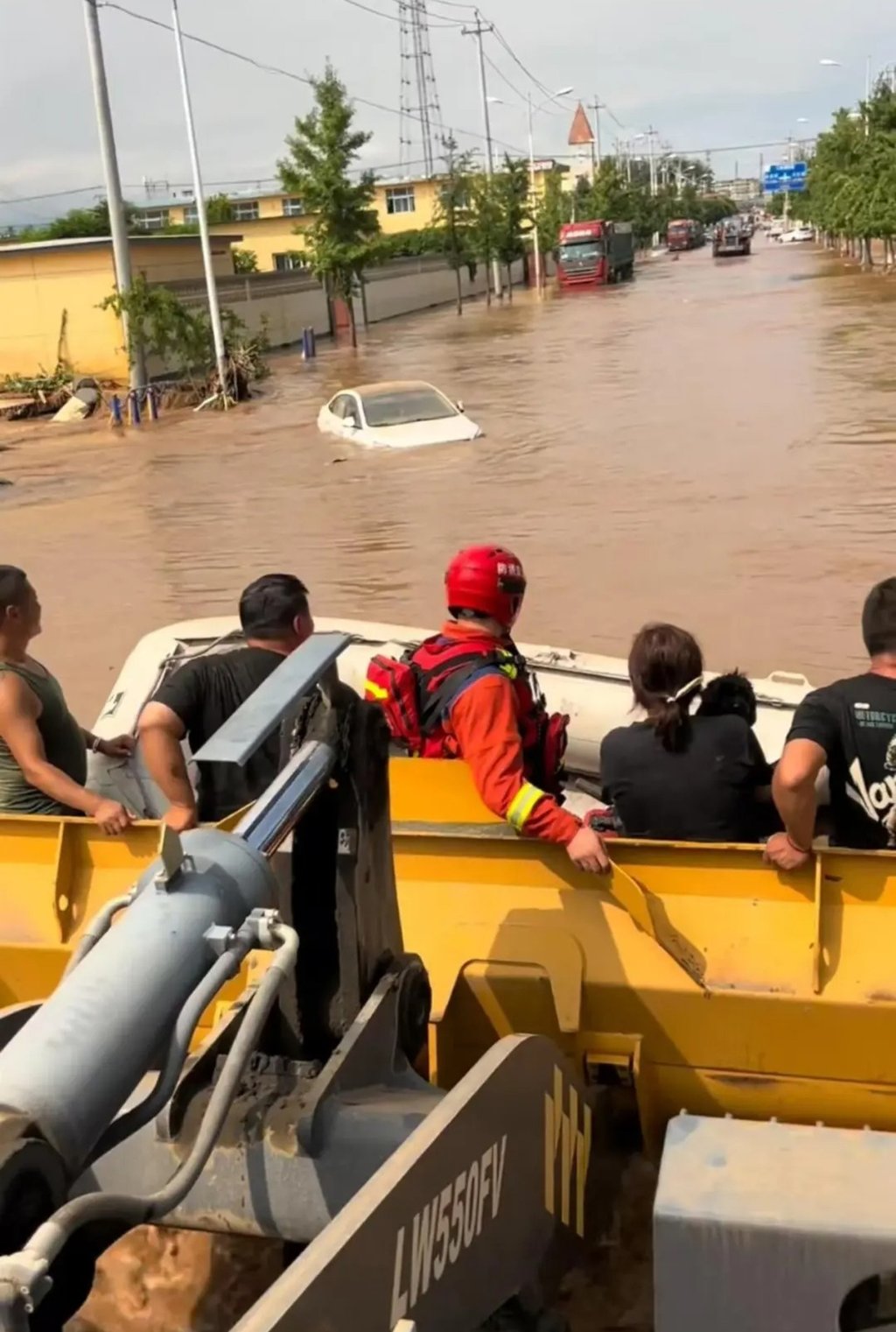 Wang used the mechanical bucket of his bulldozer to carry flood victims to safety. Photo: handout Wang used the mechanical bucket of his bulldozer to carry flood victims to safety. Photo: handout