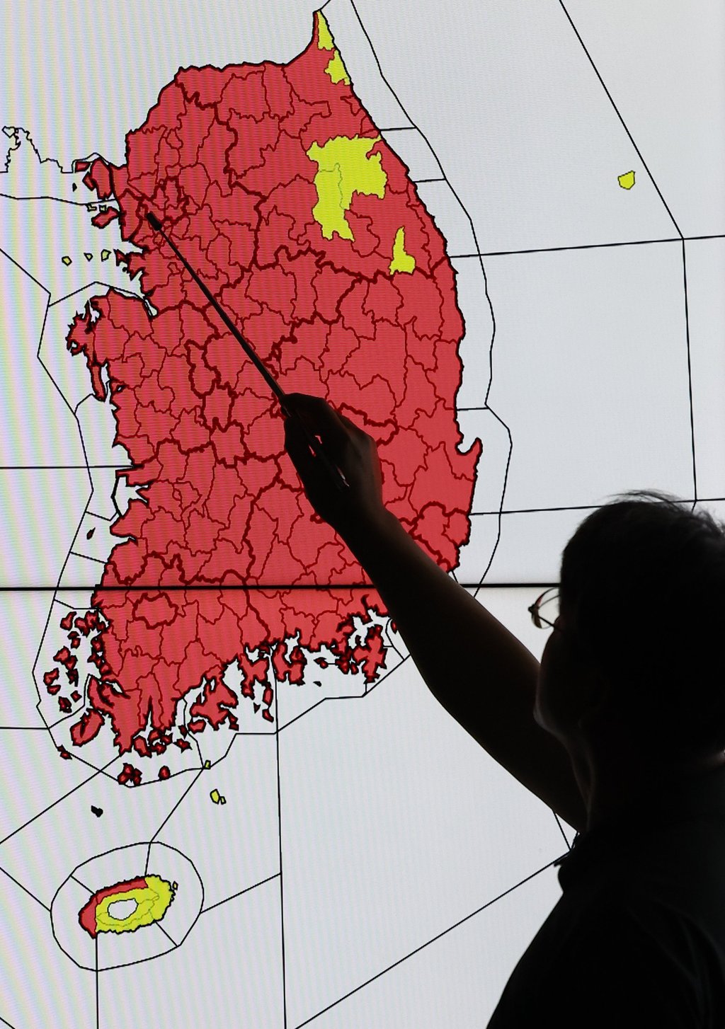 An official points to a map of South Korea indicating the areas for heat wave warnings in effect in red at the Korea Meteorological Administration in Seoul on Wednesday. Photo: EPA An official points to a map of South Korea indicating the areas for heat wave warnings in effect in red at the Korea Meteorological Administration in Seoul on Wednesday. Photo: EPA
