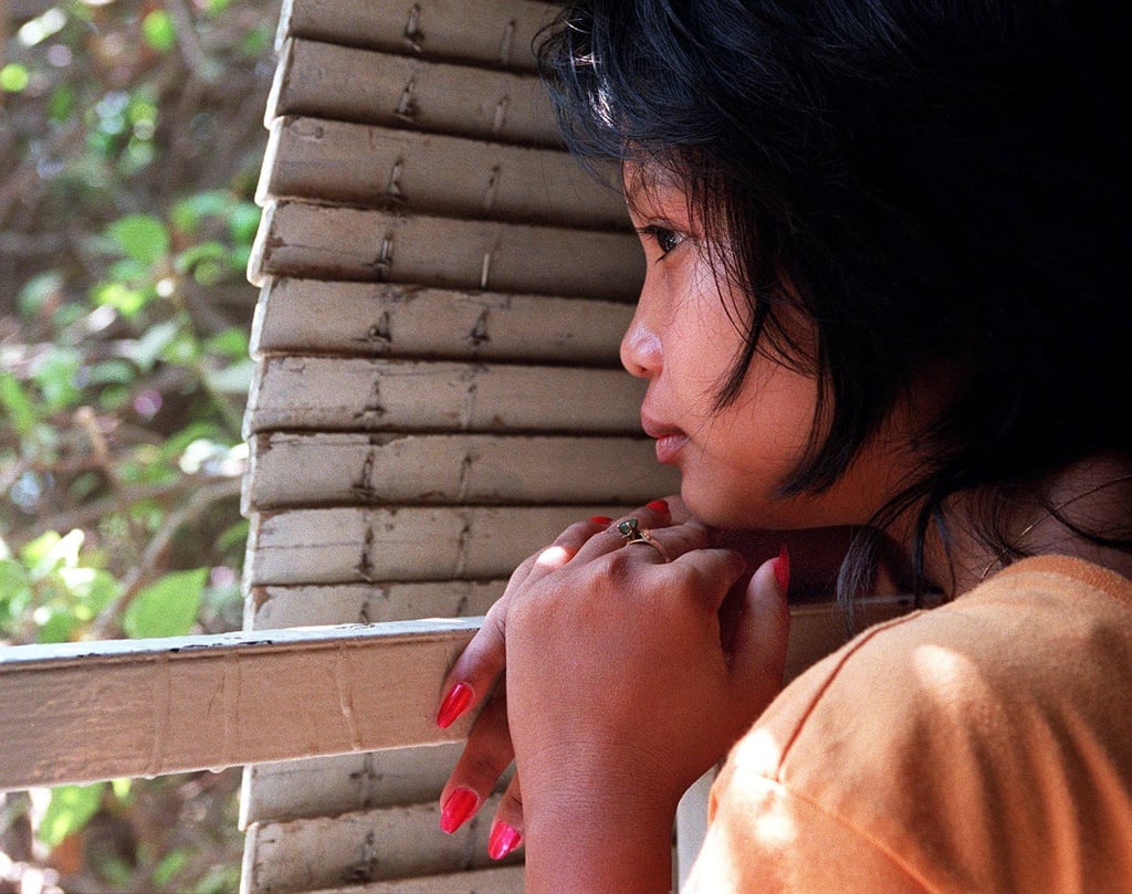 A 16-year-old girl peers out into the streets of Phnom Penh after being rescued from a brothel where she was forced to work. Photo: AFP A 16-year-old girl peers out into the streets of Phnom Penh after being rescued from a brothel where she was forced to work. Photo: AFP
