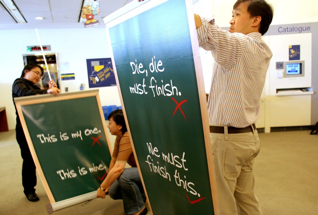 Library personnel set up standees that promote the use of correct spoken English in a library in 2006 in Singapore. The Speak Good English Movement, launched in 2000, discouraged the use of Singlish in favour of “Good English”. Photo: AP Library personnel set up standees that promote the use of correct spoken English in a library in 2006 in Singapore. The Speak Good English Movement, launched in 2000, discouraged the use of Singlish in favour of “Good English”. Photo: AP