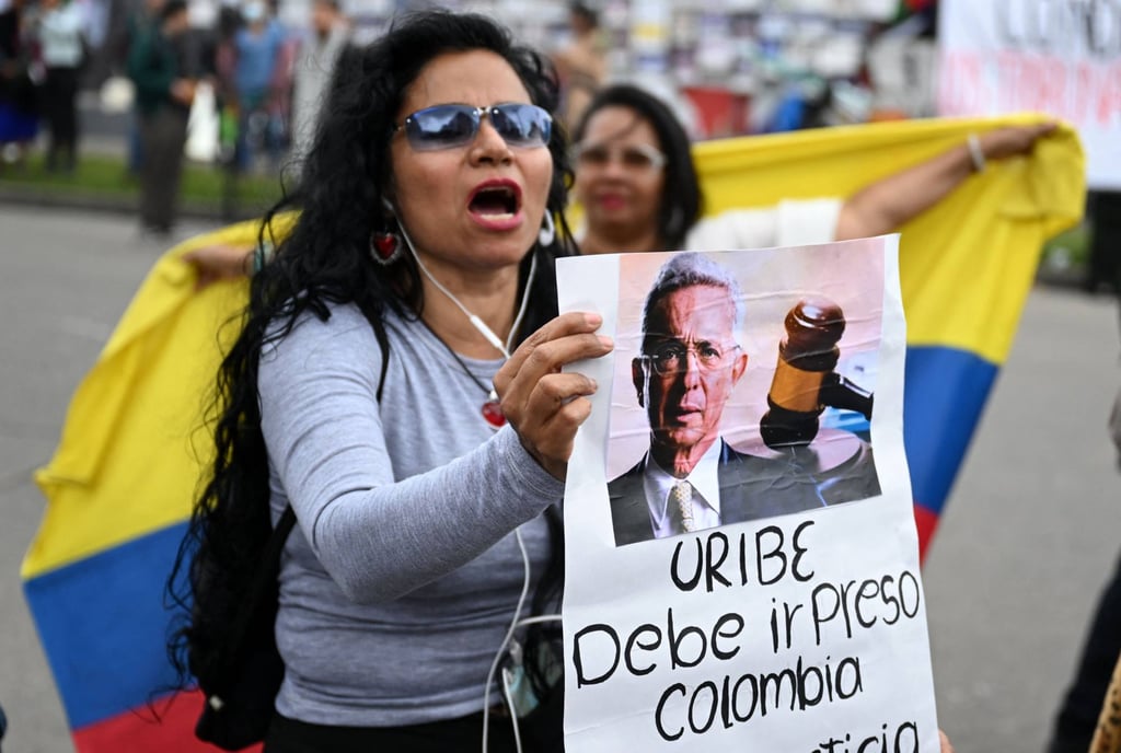 A woman holds a sign with an image of Colombian ex-president Alvaro Uribe during his sentencing hearing in Bogotá on Friday. Photo: AFP