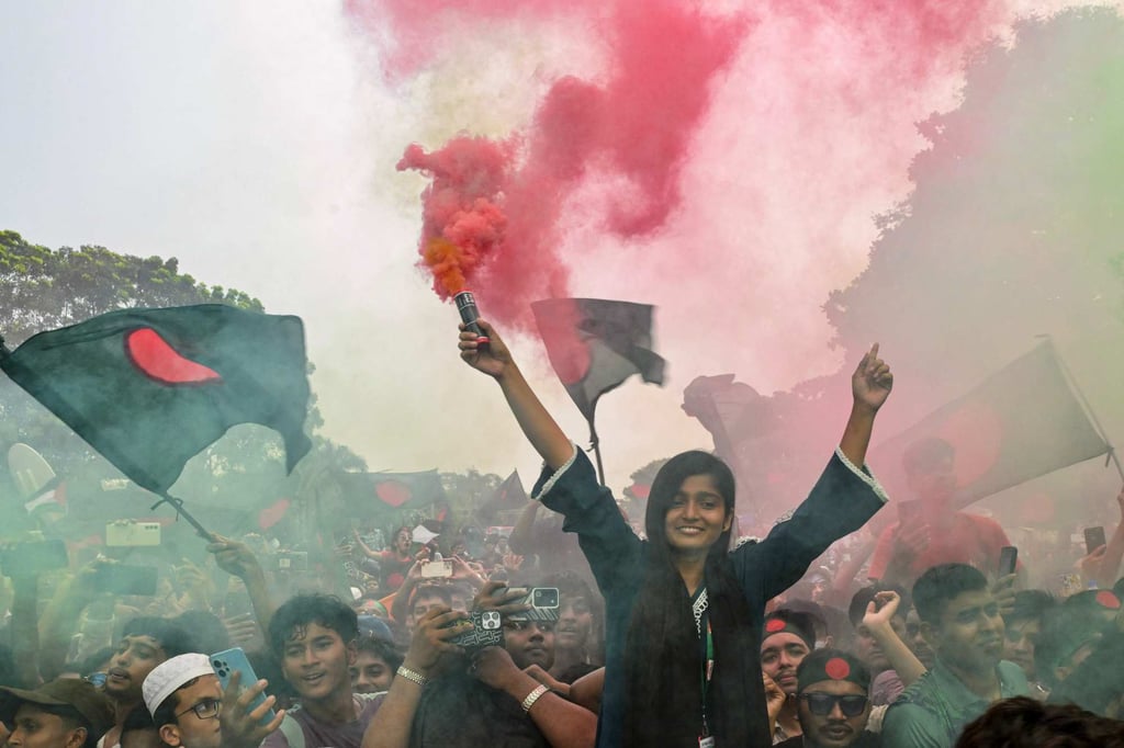 People hold Bangladesh’s national flag as they celebrate during a government-organised event in Dhaka on Tuesday. Photo: AFP