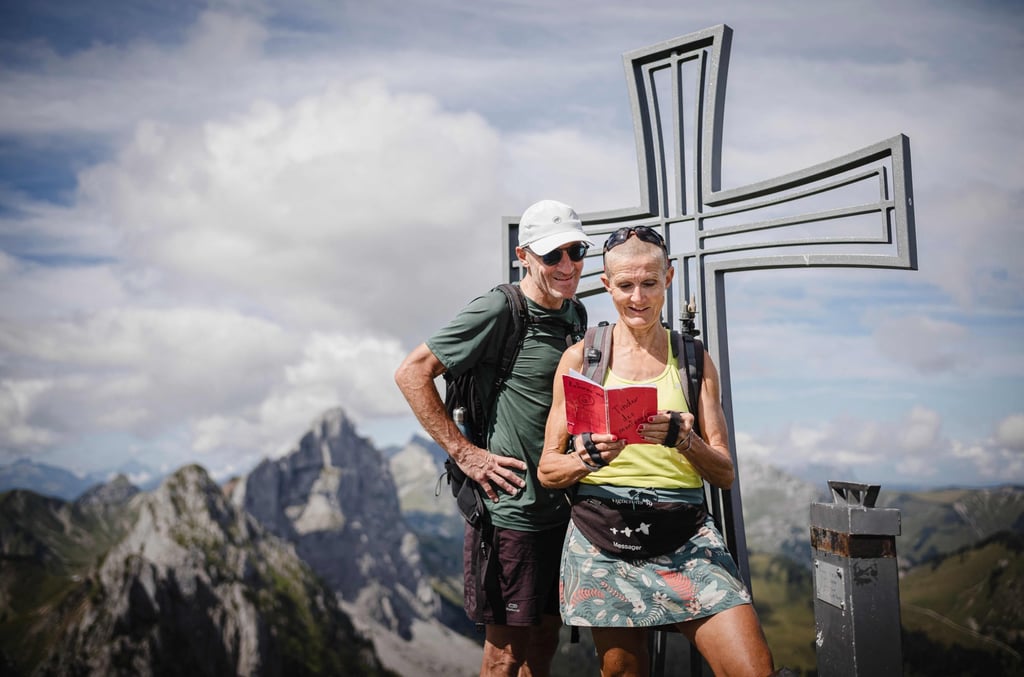 Cathy Rotzetter and Patrick read the “Mountain Tinder” notebook at the top of Wandflue peak in the Fribourg Pre-Alps. Photo: AFP