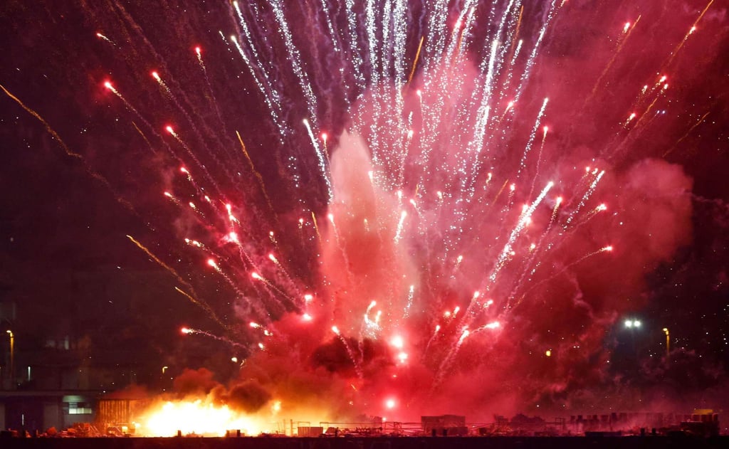 Pink and white sparks fly in all directions as a barge launching fireworks catches fire on Monday. Photo: Kyodo