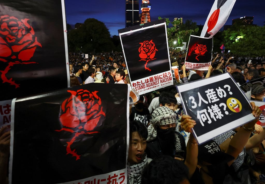 Anti-Sanseito party group members raise placards during the Sanseito’s election campaign tour at Shiba Park in Tokyo, Japan, on July 19. Photo: Reuters